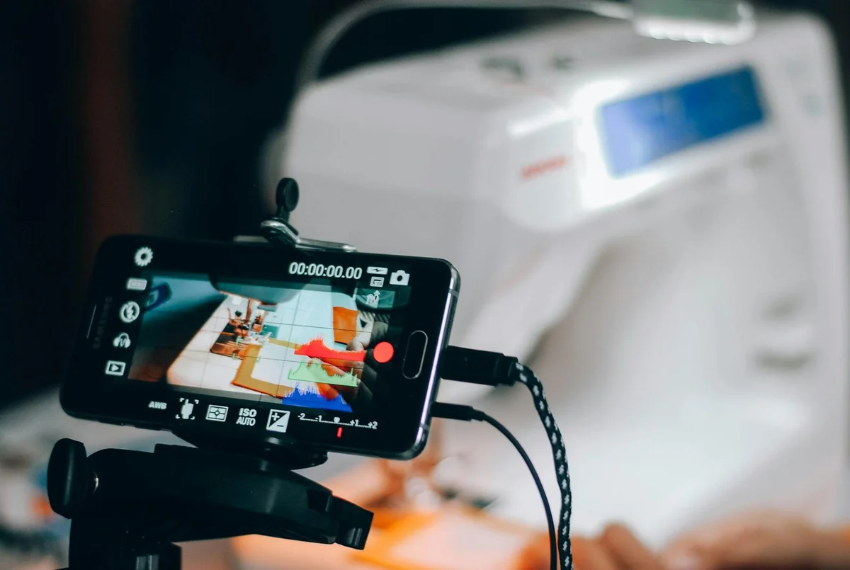 Smartphone capturing sewing machine process, perfect for DIY and crafting conten