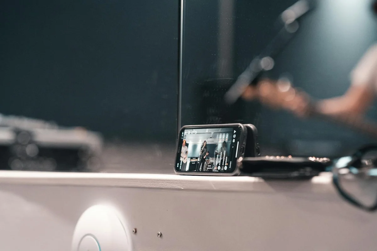 A smartphone recording a live band performance at an indoor event.