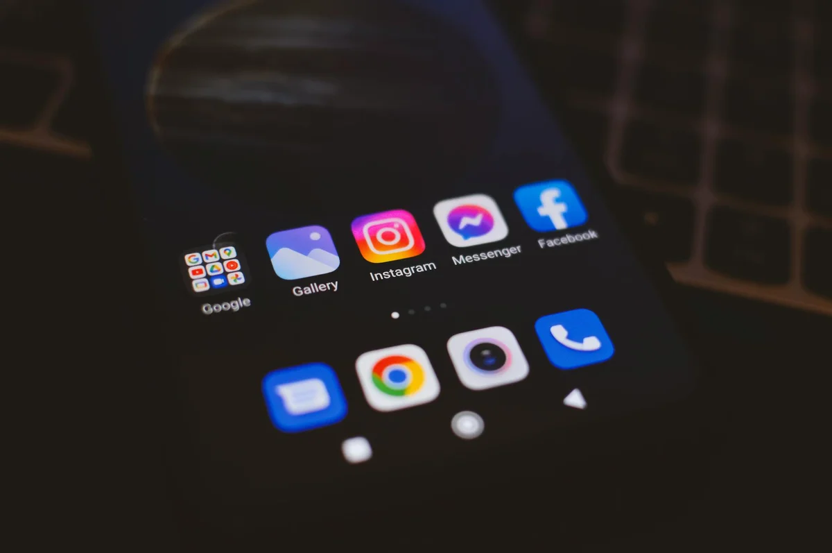 Formatos de contenido en TikTok 2026: cuál elegir y por qué — A smartphone displaying popular social media apps in a dimly lit environment, pe