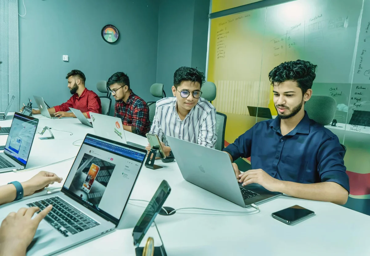 Iterar con Claude: cómo darle feedback que mejora resultados... — Group of young professionals working together in a modern office setting, using