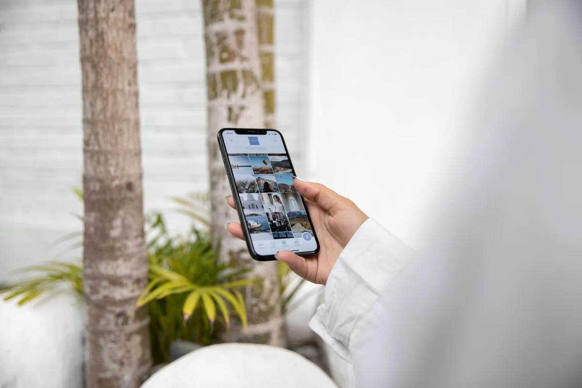 Ritmo de publicación en TikTok: cómo crear contenido sin que... — A woman using a smartphone to browse social media while standing outdoors in a t