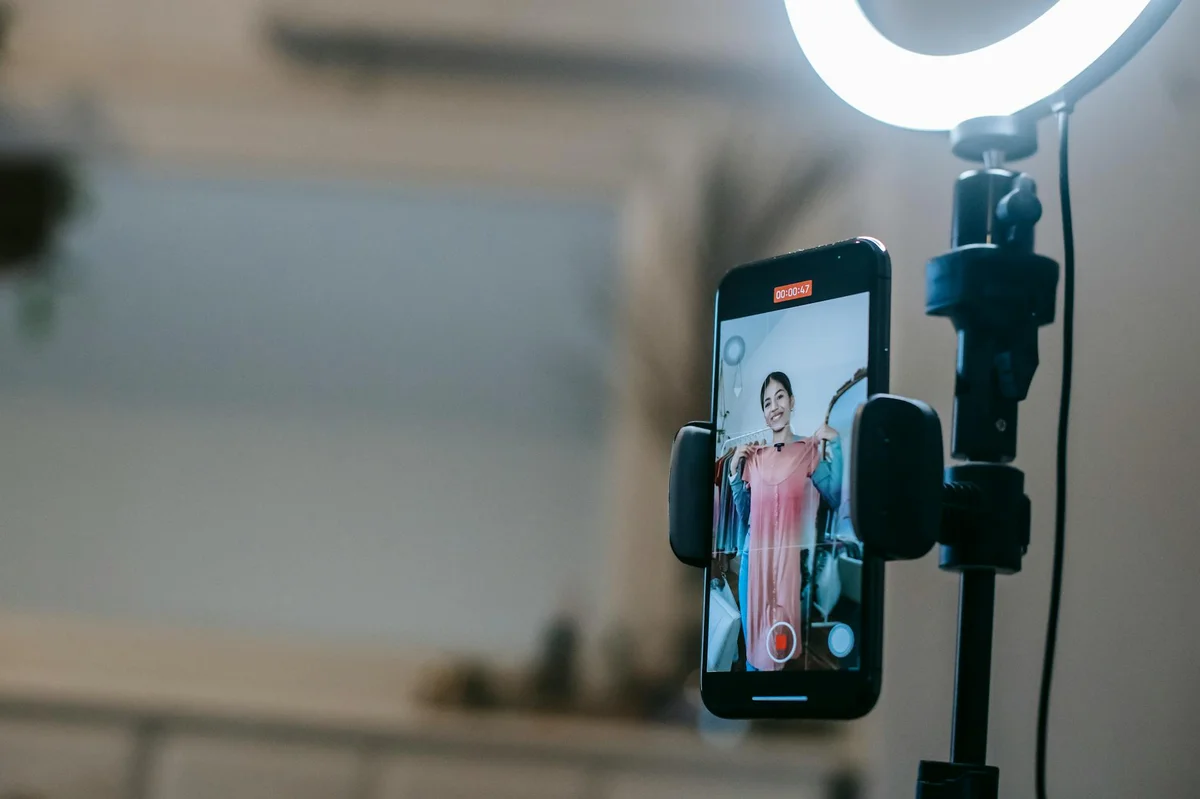Psicología de la atención en TikTok: por qué la gente se que... — Anonymous female blogger standing in room and shooting vlog on smartphone with r