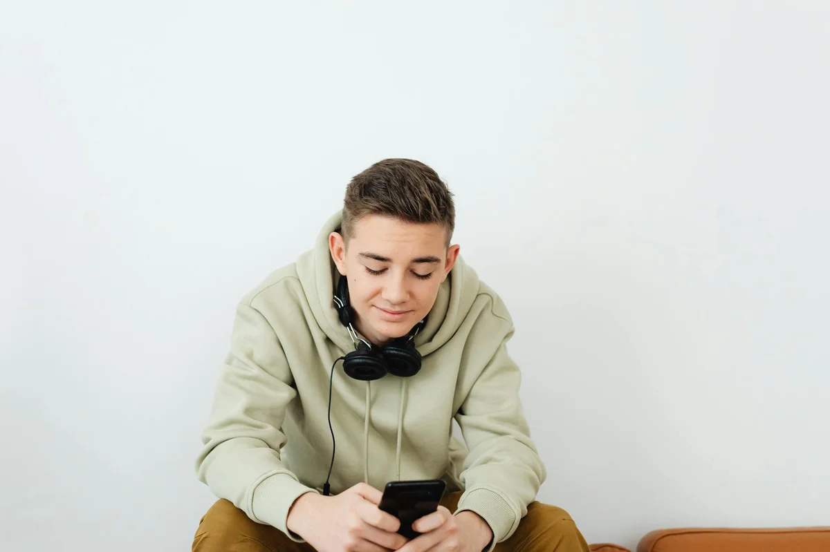 Cómo funciona TikTok: guía completa de la plataforma más all... — Young person enjoying technology, wearing casual clothes and headphones.