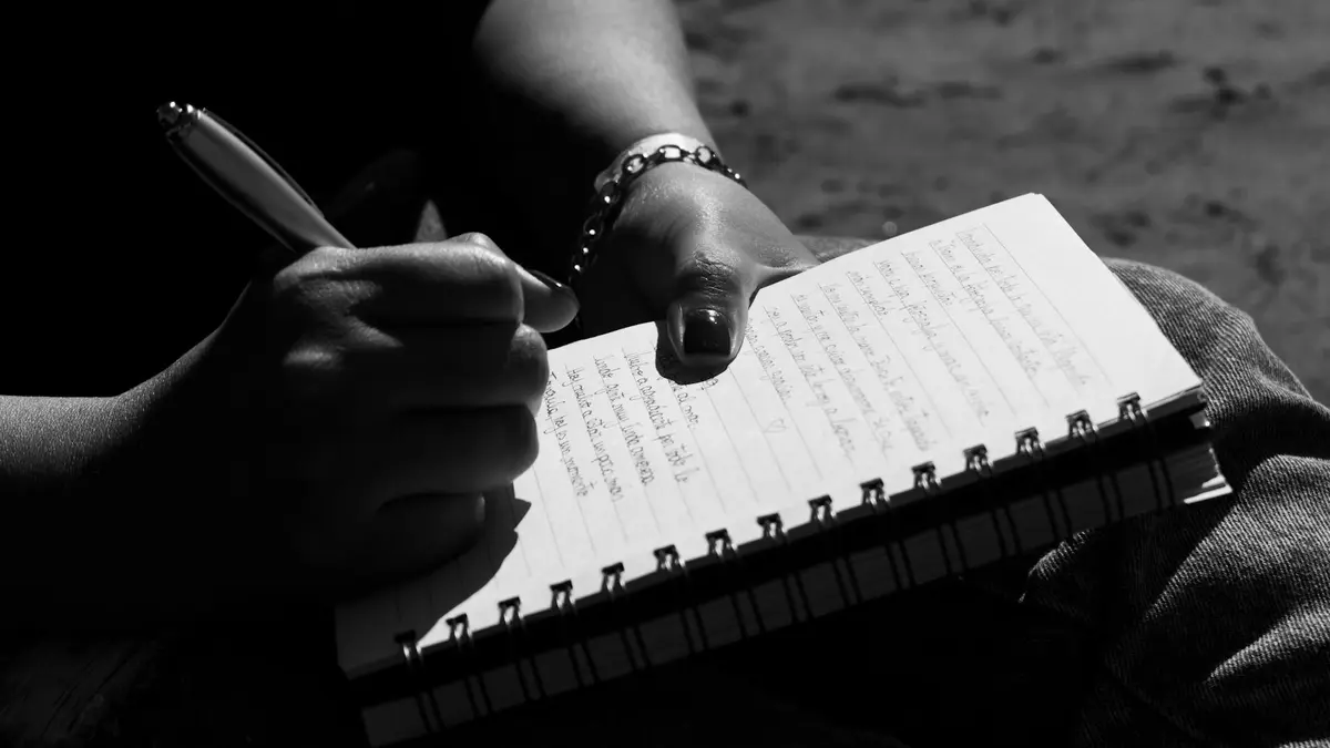 Close-up of a person writing in a notebook, captured in Mar del Plata, Argentina.